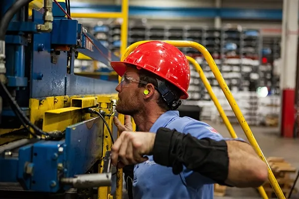 Production technician inspecting manufacturing equipment
